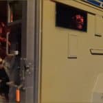 FBI SWAT operator in tactical gear sits ready to deploy from armored vehicle at night