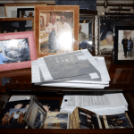 Evidence photograph from Jeffrey Epstein residence showing framed photos and drawer containing loose photographs and documents released in court files December 2025