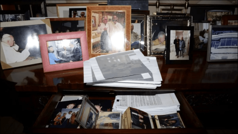 Evidence photograph from Jeffrey Epstein residence showing framed photos and drawer containing loose photographs and documents released in court files December 2025