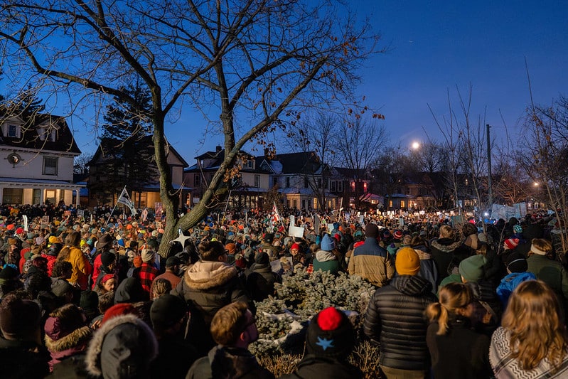Large crowd gathers at dusk in South Minneapolis neighborhood for vigil honoring Renee Good, killed by ICE agent on January 7, 2026