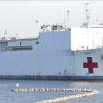 USNS Mercy hospital ship docked in port with red cross markings on hull