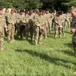 U.S. Army chaplain leads soldiers in prayer on a grassy field before a parachute jump at Fort Benning, Georgia, September 2023