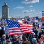 No Kings protesters fill Arlington Memorial Bridge carrying American flags and signs on March 28, 2026