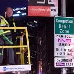 Workers install a Congestion Relief Zone sign in Manhattan the night before New York City's congestion pricing program launched in January 2025.