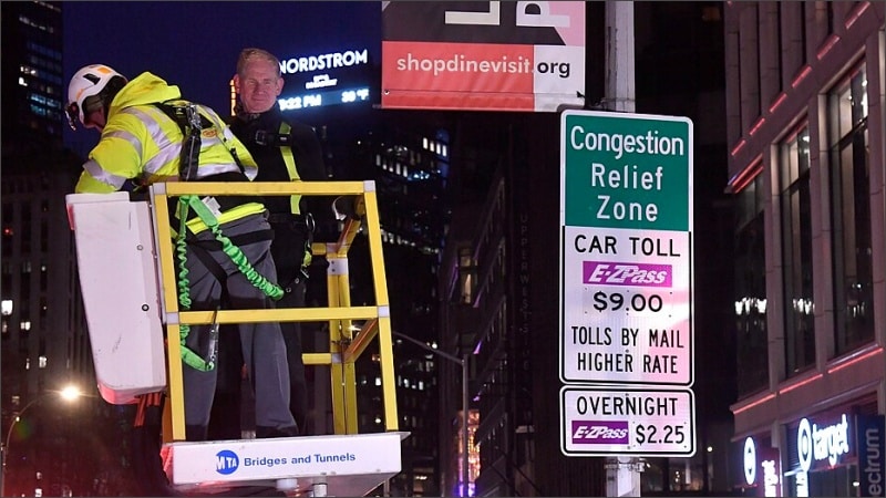Workers install a Congestion Relief Zone sign in Manhattan the night before New York City's congestion pricing program launched in January 2025.