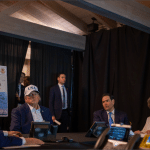 President Trump and advisers at Mar-a-Lago conference table with Operation Epic Fury map of Iran strikes displayed behind them