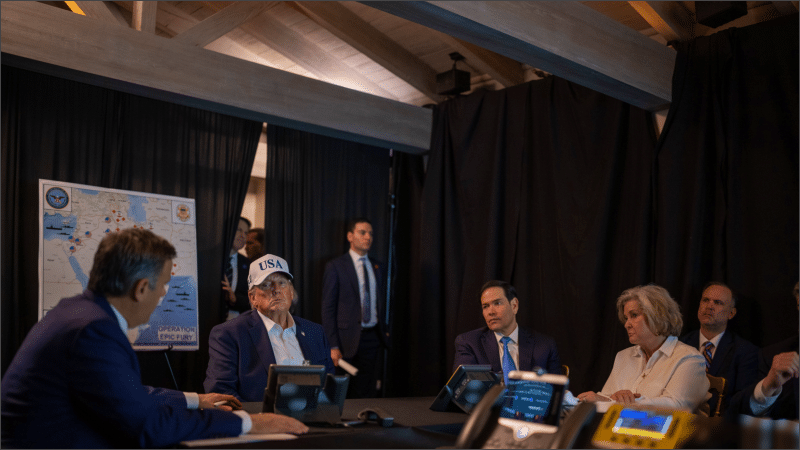 President Trump and advisers at Mar-a-Lago conference table with Operation Epic Fury map of Iran strikes displayed behind them