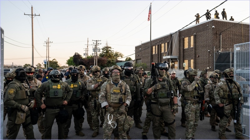 Border Patrol and ICE agents in tactical gear and face coverings massed outside the Broadview ICE detention facility near Chicago