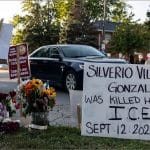 Roadside memorial with flowers, candles, and a handwritten sign reading "Silverio Villegos Gonzalez was killed here by I.C.E. Sept. 12. 2025" in Franklin Park, Illinois.