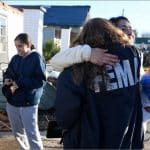 FEMA housing inspector hugging tornado survivor outside damaged home in Mayfield, Kentucky