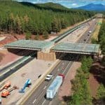 Aerial view of the Willard Springs wildlife overpass under construction over Interstate 17 in forested northern Arizona