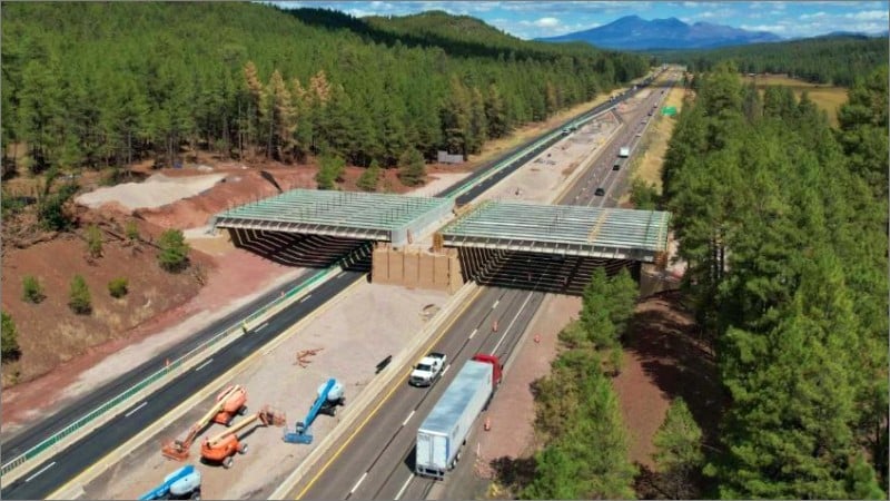 Aerial view of the Willard Springs wildlife overpass under construction over Interstate 17 in forested northern Arizona