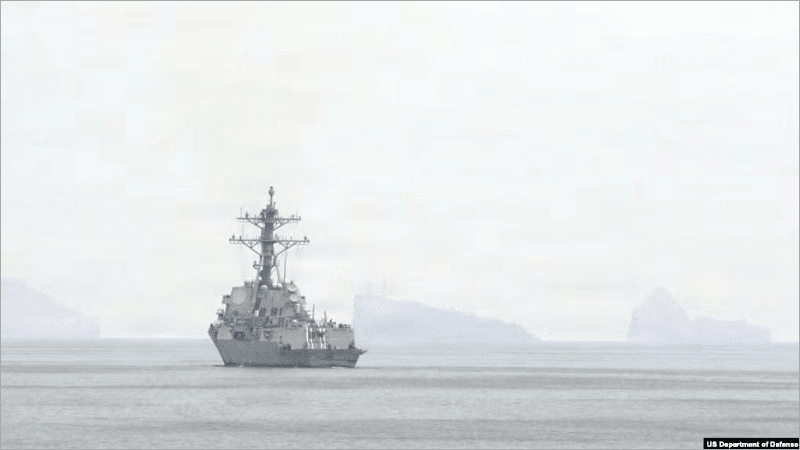 U.S. Navy destroyer transiting the hazy Strait of Hormuz near the Iranian coast