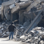 Man standing alone before the rubble of a collapsed building after Israeli airstrikes in the Bachoura neighborhood of Beirut, Lebanon