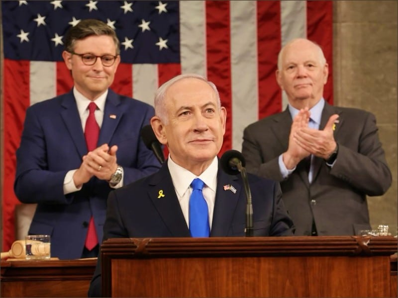 Benjamin Netanyahu speaks at the House rostrum with Speaker Mike Johnson and Senator Ben Cardin applauding behind him