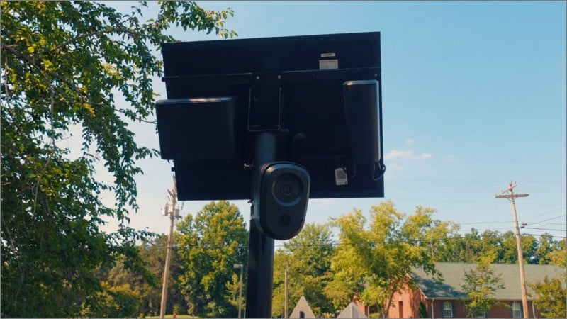 Flock Safety automated license plate reader camera and solar panel mounted on a pole in a residential neighborhood