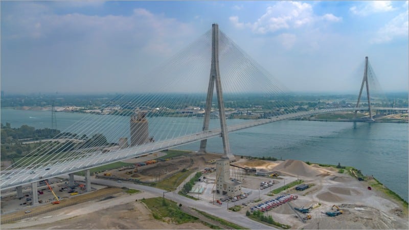 Aerial view of the Gordie Howe International Bridge cable-stayed span crossing the Detroit River between Detroit and Windsor before its July 2026 opening