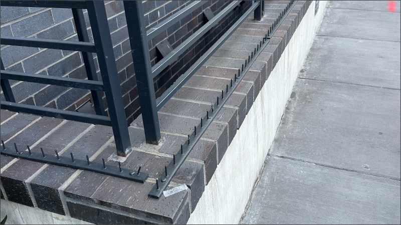 Metal spikes installed on a brick ledge in Washington DC, hostile architecture designed to prevent people from sitting or resting