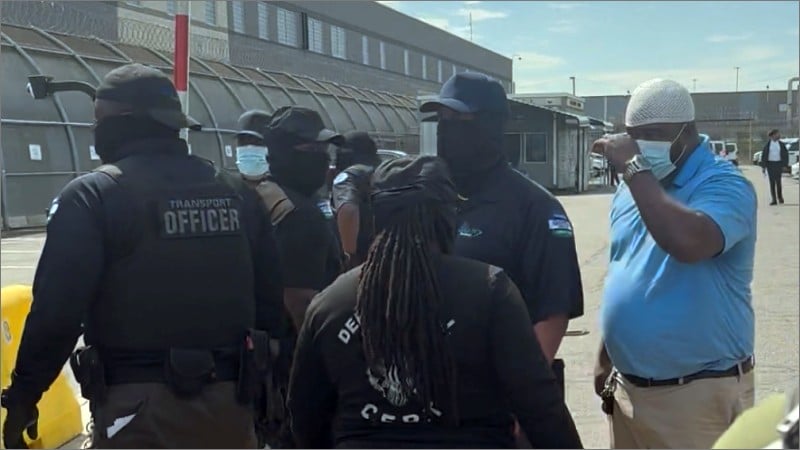 Masked GEO Group transport officers outside Delaney Hall ICE detention facility in Newark