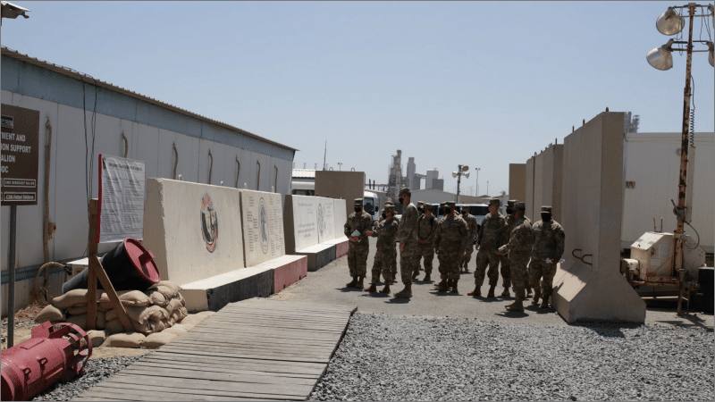 Soldiers stand between concrete blast walls and prefabricated buildings at Port Shuaiba, Kuwait, in 2021