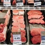 Steaks with price tags in a grocery store beef case