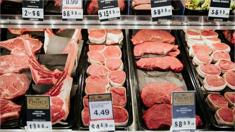 Steaks with price tags in a grocery store beef case
