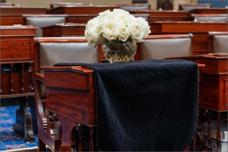 Black-draped Senate desk of the late Sen. Lindsey Graham with white roses