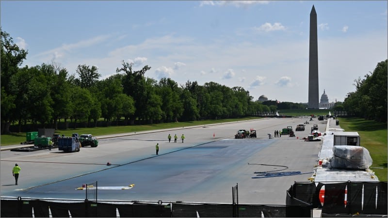 Workers painting the drained Lincoln Memorial Reflecting Pool blue with the Washington Monument and Capitol dome in the background, April 2026