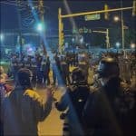 Riot police with shields face protesters at night outside Delaney Hall immigration detention center in Newark, New Jersey