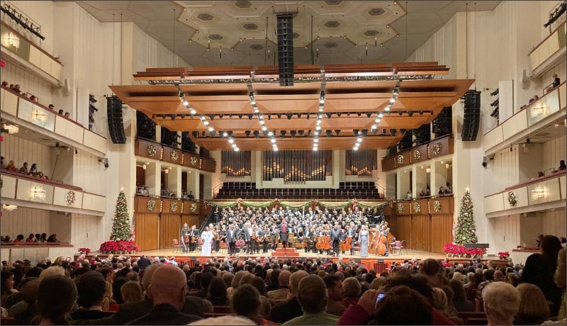 Packed Kennedy Center Concert Hall audience watching the annual Messiah sing-along with orchestra, chorus, and Christmas trees on stage