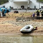 New York State search and rescue team with raft and helicopter on a flood-damaged riverbank near a church in western North Carolina after Hurricane Helene