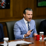 Defense Secretary Pete Hegseth speaks next to a smiling President Donald Trump during a Camp David cabinet meeting on July 31, 2026.