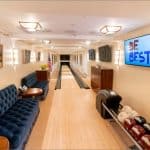 White House bowling alley after its 2019 renovation, with a single lane, tufted blue sofas and a Be Best sign on the wall screen