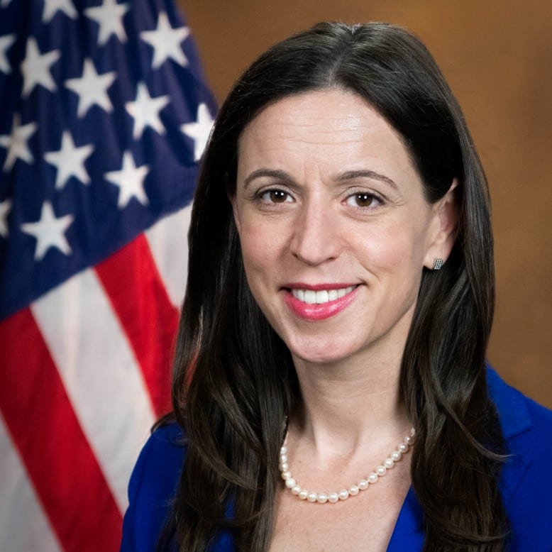 Official portrait of former Justice Department pardon attorney Liz Oyer in front of an American flag