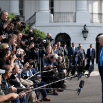 Donald Trump surrounded by press pool reporters, cameras and microphones outside the White House
