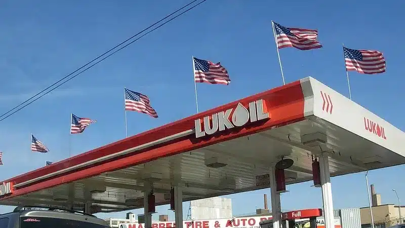 American flags flying above a red and white Lukoil gas station canopy in New York City