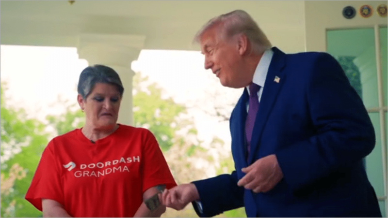 President Donald Trump hands a bill to Sharon Simmons, wearing a red DoorDash Grandma T-shirt, on the Oval Office colonnade at the White House